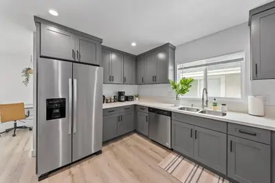 a kitchen with gray cabinets and a stainless steel refrigerator at South Bay 3 bed Escape! in Harbor City