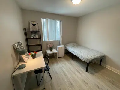 a small bedroom with a bed and a desk at The Blue Hostel - Near USC, BMO in Los Angeles