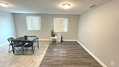 a dining room with a table and chairs and two windows at The Blue Hostel - Near USC, BMO in Los Angeles