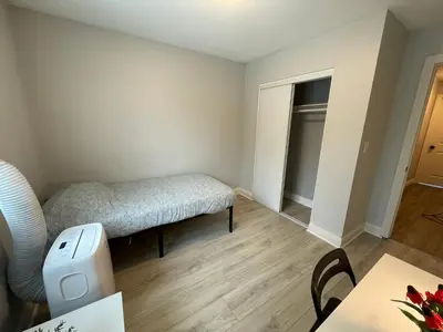 a small bedroom with a bed and a table at The Blue Hostel - Near USC, BMO in Los Angeles