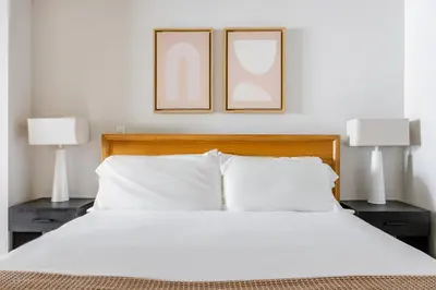 a bedroom with two pictures above a bed with two lamps at Blueground Downtown elevator nr parks LAX-1247 in Los Angeles