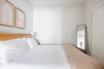 a bedroom with a white bed and a mirror at Blueground Downtown elevator nr parks LAX-1247 in Los Angeles