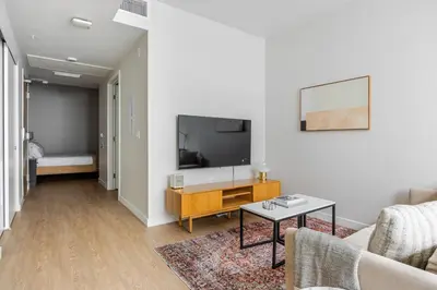 a living room with a tv and a couch and a table at Blueground Downtown elevator nr parks LAX-1247 in Los Angeles