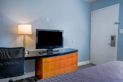 a room with a desk with a television and a lamp at Economy Inn Buttonwillow Bakersfield I-5 in Buttonwillow