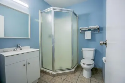 a bathroom with a shower and a toilet and a sink at Economy Inn Buttonwillow Bakersfield I-5 in Buttonwillow