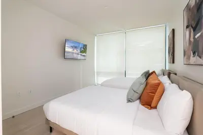 a white room with a bed and a couch at Luxurious 2-Bedroom Retreat in Santa Monica in Los Angeles
