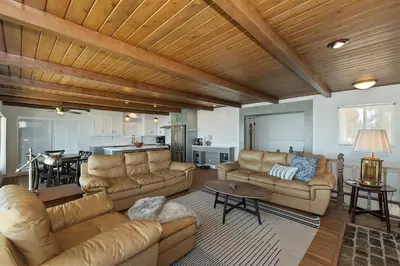 a living room with leather couches and a kitchen at Lake Gregory Skyline Ridge in Crestline