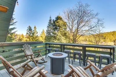 a patio with chairs and a table on a deck at Family-Friendly Lake Arrowhead Cabin with Game Room! in Lake Arrowhead