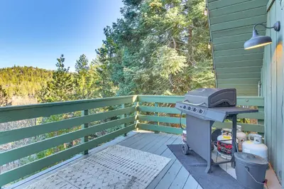 a grill sitting on a deck next to a fence at Family-Friendly Lake Arrowhead Cabin with Game Room! in Lake Arrowhead