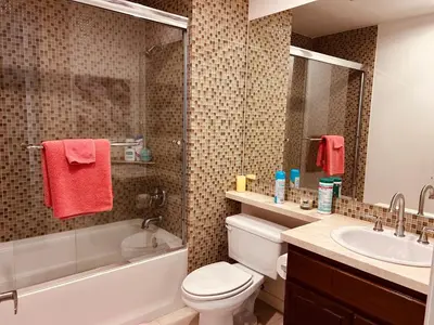 a bathroom with a white tub and a toilet and a sink at Cozy private room and bathroom in prime location with rooftop views 30 day stays or more in Los Angeles
