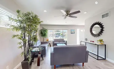 a living room with a ceiling fan and plants at Modern Oasis for Families & Business, Pets OK, EV in Orange