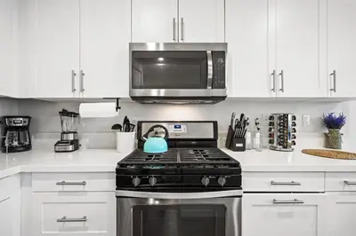 a kitchen with a stove and a microwave at Gorgeous Family Home, Close to Frwys, Hospitals & Sports Arenas, Pets OK in Orange