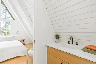 a bathroom with a sink and a bed in a room at Luxury A-Frame Retreat in Lake Arrowhead