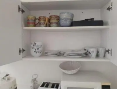 a kitchen with a shelf with cups and dishes at Best Prime Location Hollywood Private House in Los Angeles
