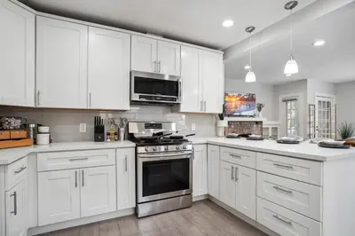 a kitchen with white cabinets and a stove top oven at Foosball l LA Mural l DTLA l UnivStudios l BevHills in Glendale