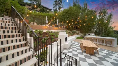 a patio with a wooden bench and a wooden table at Casa Cortona by Stay Awhile Villas in Los Angeles