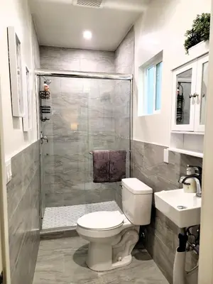 a bathroom with a shower and a toilet and a sink at Perfectly located Pico Robertson ground floor 3 bedroom apartment Walk to restaurants WIFI TV Game Console Parking 5 minutes to Rodeo Drive in Los Angeles