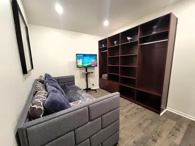 a living room with a couch and a flat screen tv at Perfectly located Pico Robertson ground floor 3 bedroom apartment Walk to restaurants WIFI TV Game Console Parking 5 minutes to Rodeo Drive in Los Angeles