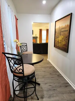 a dining room with a table and chairs and a painting at Perfectly located Pico Robertson ground floor 3 bedroom apartment Walk to restaurants WIFI TV Game Console Parking 5 minutes to Rodeo Drive in Los Angeles
