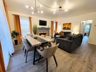 a living room with a table and chairs and a couch at Perfectly located Pico Robertson ground floor 3 bedroom apartment Walk to restaurants WIFI TV Game Console Parking 5 minutes to Rodeo Drive in Los Angeles