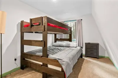 a bedroom with a wooden bunk bed with a dresser at Midnight Pines Cabin - Cozy Get-Away Near Slopes! in Big Bear Lake