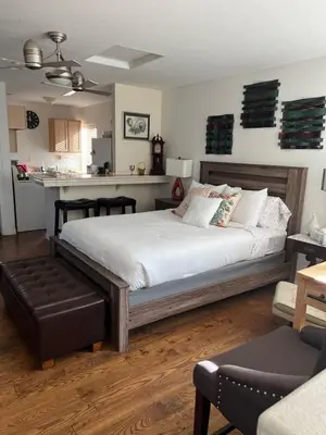 a bedroom with a large bed and a kitchen at B and G Studio Space Guesthouse in San Bernardino