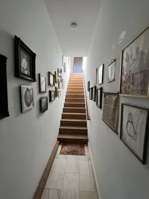 a hallway with a staircase with pictures on the walls at B and G Studio Space Guesthouse in San Bernardino