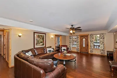 a living room with leather furniture and a ceiling fan at Big 10 Luxury Cabin/Walk to Snow Summit- HotTub in Big Bear Lake
