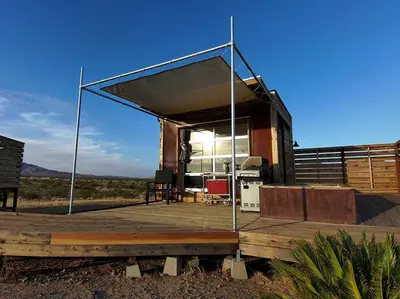 a house with a large canopy on a wooden deck at Secluded Glamping Eco-Pod Rental in the Mojave Desert near Ridgecrest, California in Ridgecrest