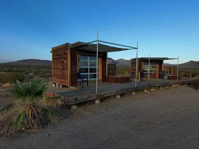 a cabin in the desert with mountains in the background at Secluded Glamping Eco-Pod Rental in the Mojave Desert near Ridgecrest, California in Ridgecrest