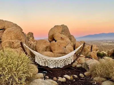 a hammock on a pile of rocks in the desert at Stunning Geo Dome with Joshua Tree vibes in Palmdale
