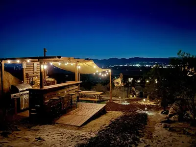 a deck with a tent and a picnic table with lights at Stunning Geo Dome with Joshua Tree vibes in Palmdale