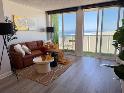 a living room with a couch and a table at Oceanfront 2 BR w Pool & Parking 234 in Hermosa Beach