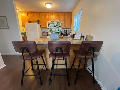 a kitchen with a counter with three bar stools at Mini-Home in Whittier in Whittier