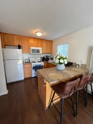 a kitchen with a white refrigerator and a table with chairs at Mini-Home in Whittier in Whittier