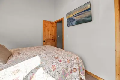 a bedroom with a bed and a painting on the wall at Lakeside Cottage, Charming 3-BDRM Retreat W Hottub in Big Bear Lake