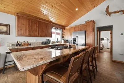 a kitchen with wooden cabinets and a large counter top at Lakeside Cottage, Charming 3-BDRM Retreat W Hottub in Big Bear Lake