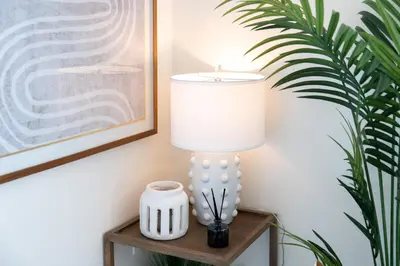 a lamp on a table next to a plant at Newly built vacation home with large backyard in Diamond Bar