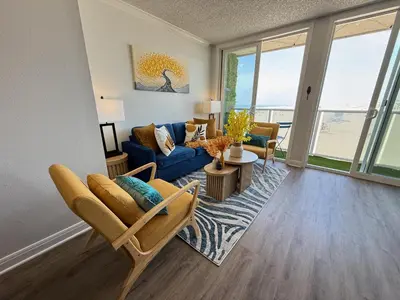 a living room with a blue couch and a table at Oceanfront Sanctuary 1 BR Beach Access 218 in Hermosa Beach