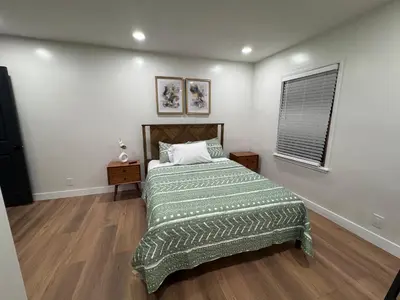 a bedroom with a bed with a green comforter and a window at Modern Bedroom in Long Beach 1 in Long Beach