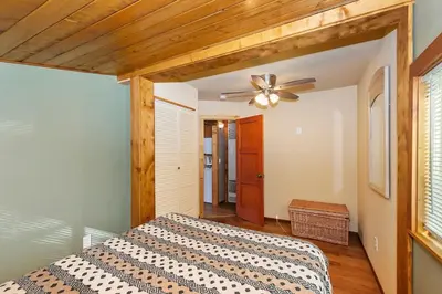 a bedroom with a bed and a ceiling fan at Rosy Cozy Cottage-Walk to Big Bear Lake in Big Bear Lake