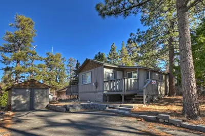 a cabin in the woods with a driveway at Rosy Cozy Cottage-Walk to Big Bear Lake in Big Bear Lake
