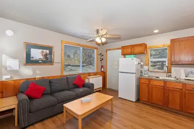 a living room with a couch and a kitchen at Rosy Cozy Cottage-Walk to Big Bear Lake in Big Bear Lake