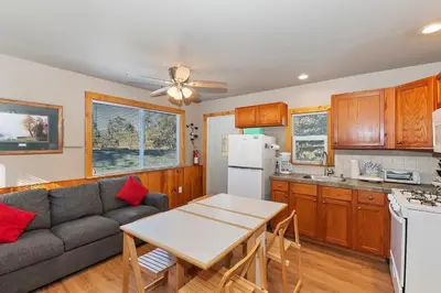 a kitchen and living room with a couch and a table at Rosy Cozy Cottage-Walk to Big Bear Lake in Big Bear Lake