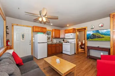 a living room with a couch and a white refrigerator at Rosy Cozy Cottage-Walk to Big Bear Lake in Big Bear Lake