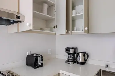 a kitchen with white cabinets and a coffee maker at Blueground Downtown elevator nr parks LAX-1248 in Los Angeles