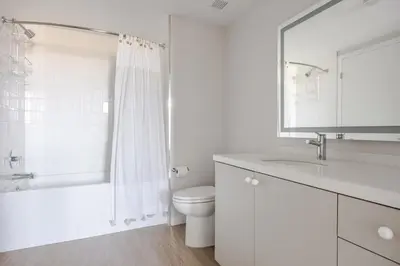 a white bathroom with a toilet and a sink at Blueground Downtown elevator nr parks LAX-1250 in Los Angeles