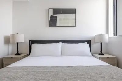 a bedroom with a white bed with two lamps at Blueground Downtown elevator nr parks LAX-1250 in Los Angeles