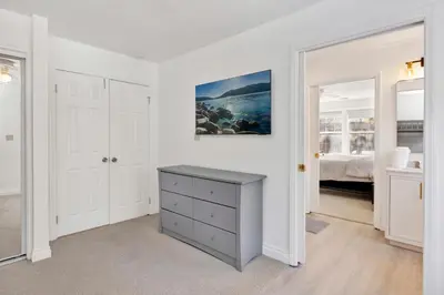 a white room with a dresser and a bedroom at Castlewood Retreat at Big Bear Central Modern Family Chalet in Big Bear Lake