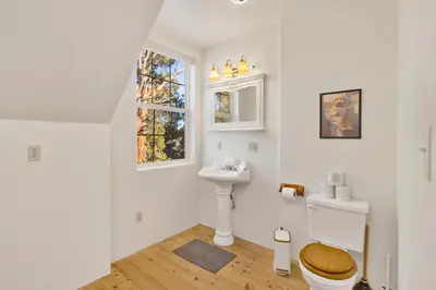 a white bathroom with a toilet and a sink at Castlewood Retreat at Big Bear Central Modern Family Chalet in Big Bear Lake